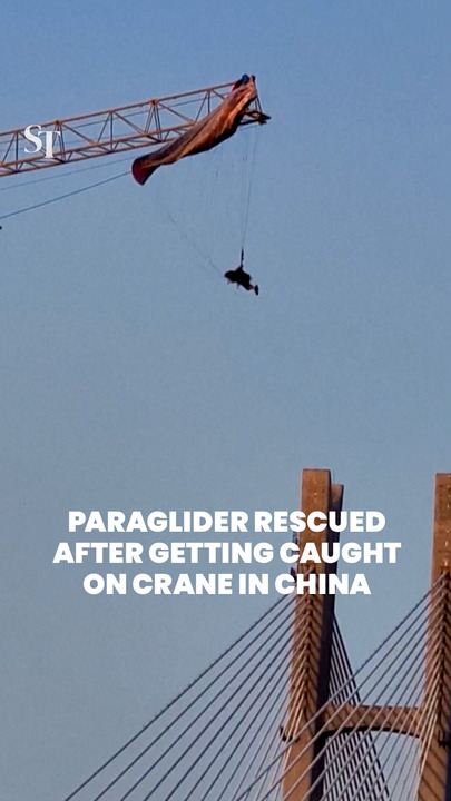 Paraglider rescued after getting caught on crane in China
