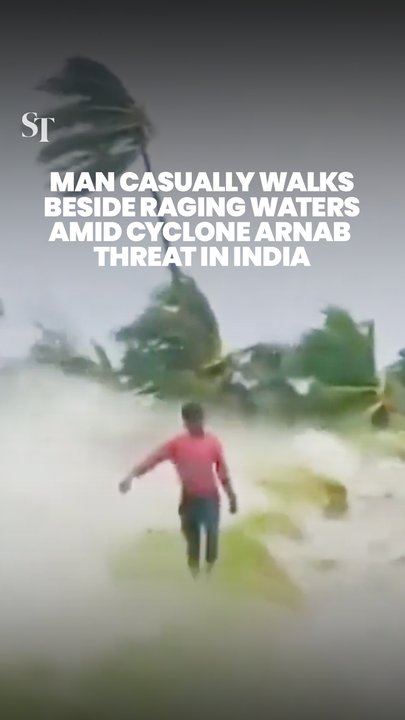 Man walks along lakeshore, unfazed by Cyclone Arnab in India