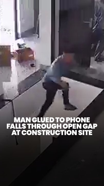 Man glued to phone falls through open gap at construction site