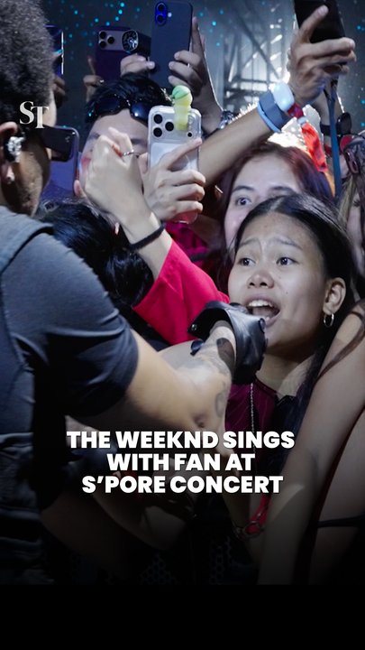The Weeknd hands mic to a screaming fan amongst the 55,000 crowd on his Oct 2 concert in Singapore